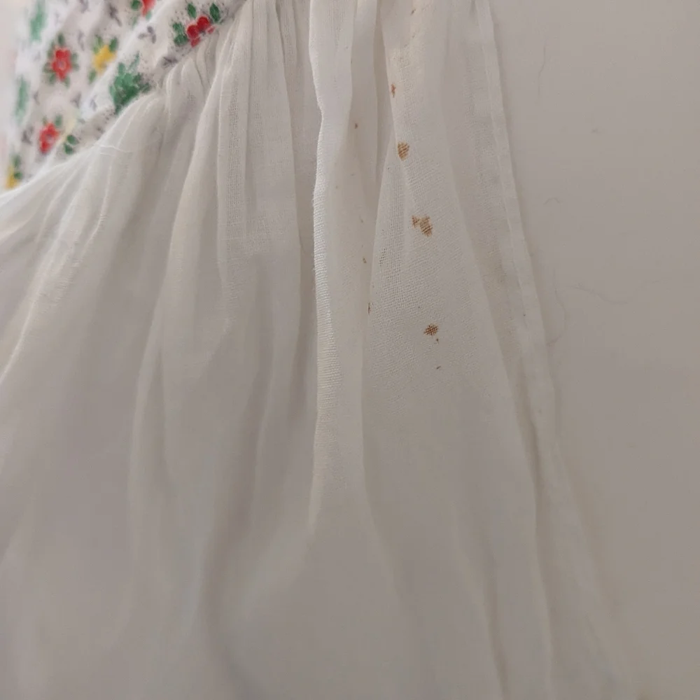 Vintage handmade white apron with red, green and red floral print.